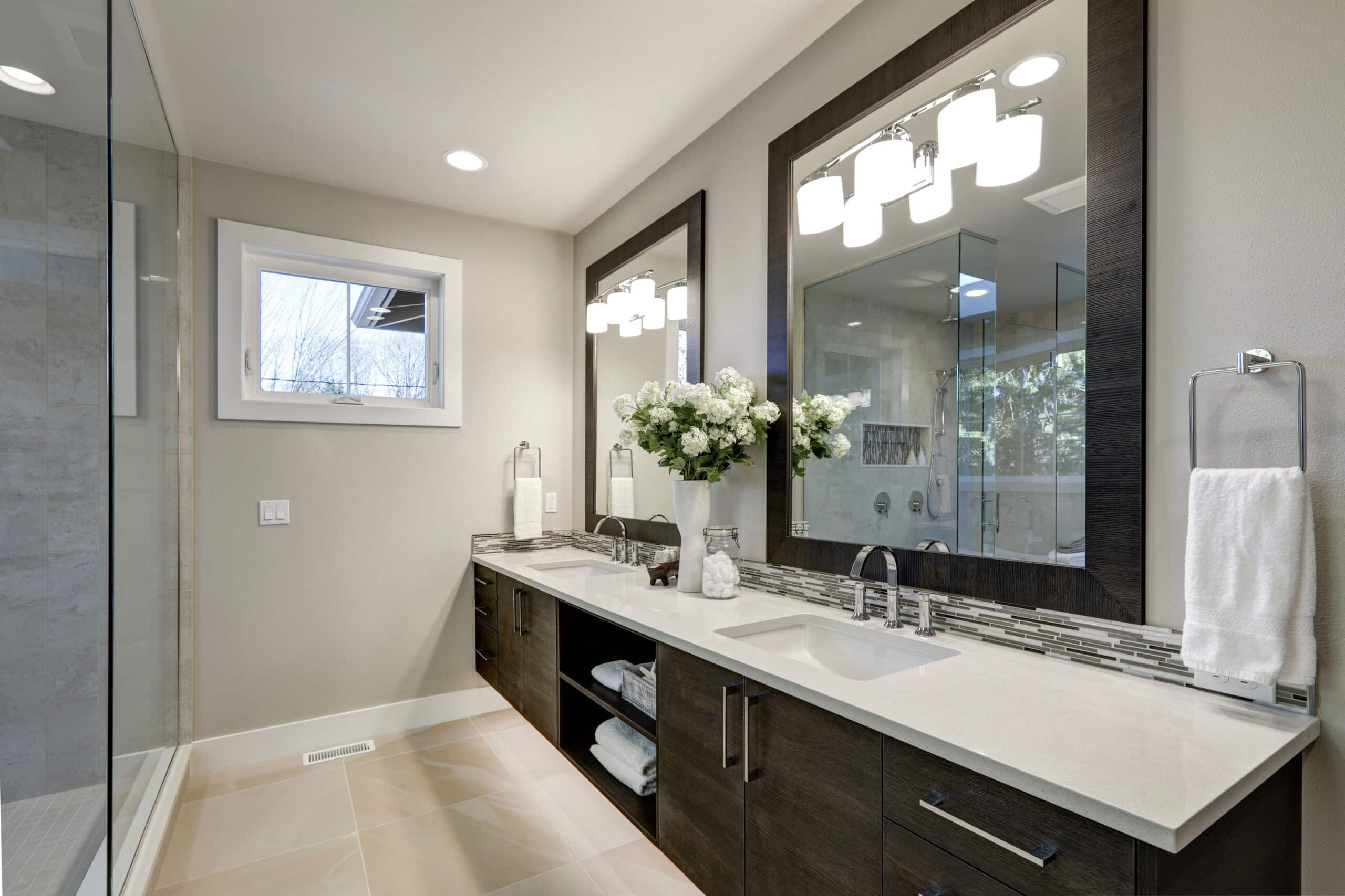 Spacious bathroom in gray tones with long double sink vanity and heated floors. Northwest, USA